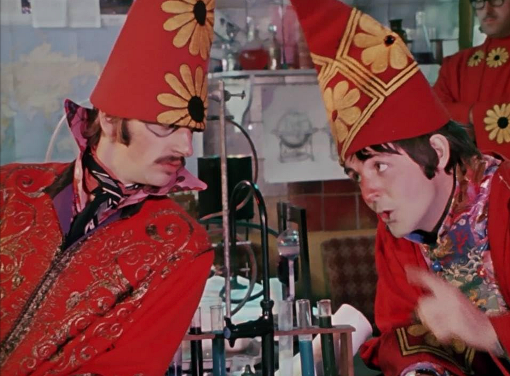 The Beatles on red pointy hats with sunflowers