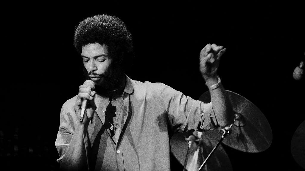 Gil Scott-Heron holds a microphone as he performs in Chicago, 1978.