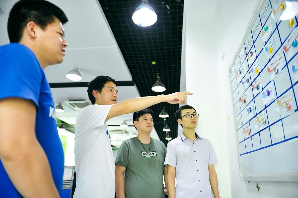 Tech workers in front of a planning board